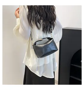 Sac à bandoulière noir géométrique porté par un mannequin dans un studio minimaliste