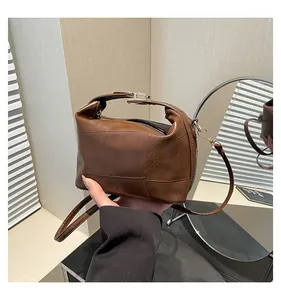 Vue détaillée d'un sac seau patchwork marron foncé avec texture similicuir et boucles dorées