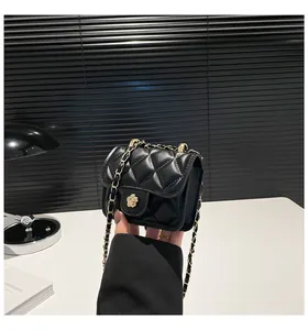 Detailaufnahme der schwarzen Stepptasche mit goldenem Kamelien-Verschluss und Kette