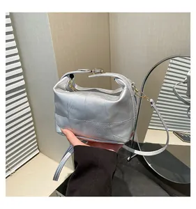 Gros plan d'un sac seau argenté avec motif patchwork carré et finitions métalliques
