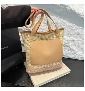 Detail of the woven straw tote bag with pink contrast base and leather patch pocket