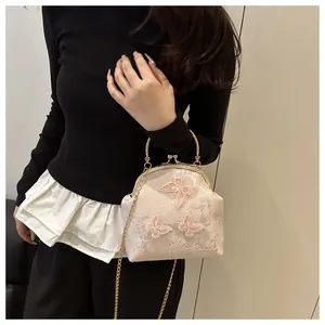 Detail of floral lace tote with 3D butterfly embroidery and golden metal handle