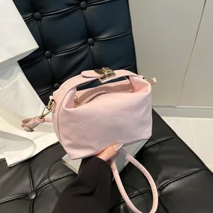 Sac seau rose en cuir grainé avec détails dorés et poignée supérieure structurée