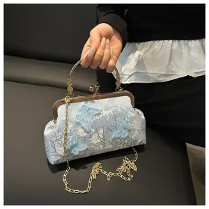 Détails de broderie et papillon 3D sur un sac bleu clair avec chaîne en métal dorée