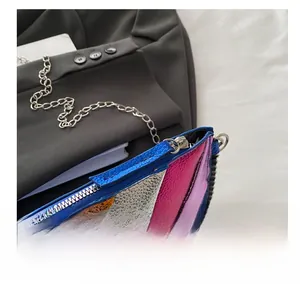 Close-up of smooth metal zipper and colorful lychee texture on chain square bag