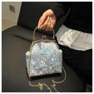 Detail of light blue jacquard tote featuring 3D butterfly embroidery and gold clasp