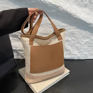 Straw woven tote bag with white mesh pattern and brown faux leather pocket details