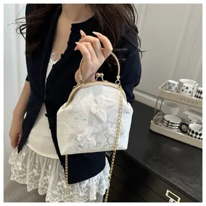 Detail of white lace handbag featuring 3D butterfly embroidery and golden frame handle