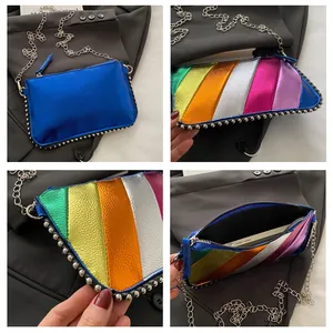 Detail view of rainbow striped chain bag with silver studs and polished blue metallic finish