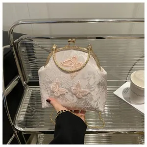 Detail of lace bag with pink butterfly embroidery and gold metal clasp closure
