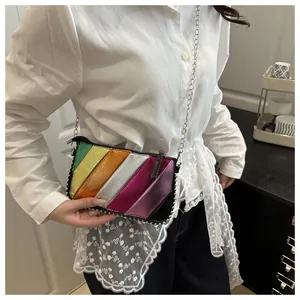 Detail of colorful rainbow striped crossbody bag with silver chain and stud embellishments