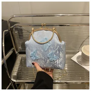 Detail of light blue floral jacquard bag with butterfly embroidery and golden hardware