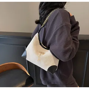 Detail of vintage beige canvas tote bag with black leather trim and golden deer charm