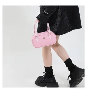 Detailed view of pink tweed cylinder handbag with woven texture and gold metal logo