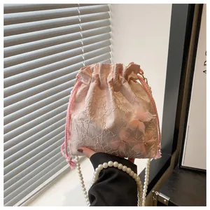 Detailed close-up of pink lace bucket bag with 3D gauze butterflies and pearl strap