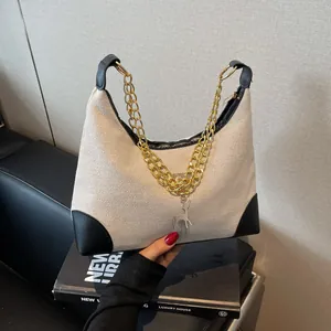 Minimalist beige woven tote bag with black leather trim and gold deer charm detail