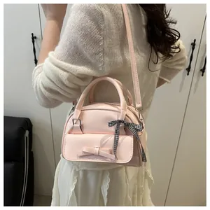 Pink bow handbag with checkered ribbon worn by model over a white lace skirt