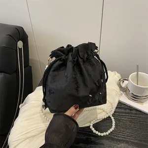 Elegant black floral bucket bag with pearl strap and drawstring closure for women
