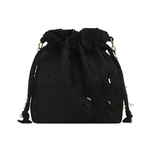 Satin drawstring bucket bag with pearl details and floral embroidery on white background