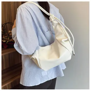 Detail of soft cream PU leather dumpling bag with knotted shoulder strap and pleats