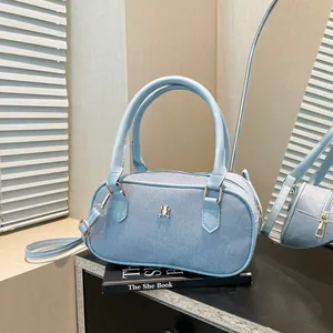 Light blue denim texture Boston bag with gold M logo and detachable shoulder strap