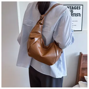 Close-up of the vintage brown pleated PU leather crescent bag with a knotted shoulder strap