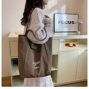 Brown canvas tote bag with BeYou print worn by model in a minimalist lifestyle setting