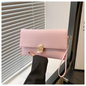 Close-up of pale pink leather square bag featuring horizontal stripes and gold metal clasp