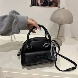 Chic black handbag with leather bow and plaid ribbon for 2025 spring summer fashion