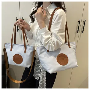 Detailed comparison of light blue tote bags in medium and small sizes with leather handles