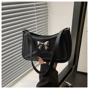 Détail du sac sous le bras en cuir PU noir avec nœud argenté et texture gaufrée