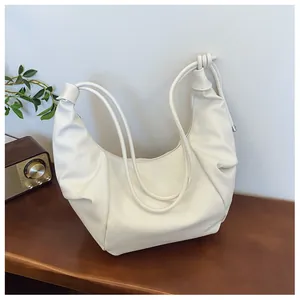 Detailed view of white PU hobo bag with litchi texture and knotted strap design