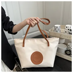 Detail of off-white nylon tote bag with brown straps and Fashion Bags text print