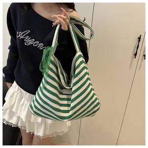 Fashionable green striped canvas tote bag with side lace ribbon detail on casual model
