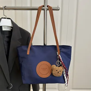 Navy blue nylon tote bag with brown leather straps and cute bear charm pendant