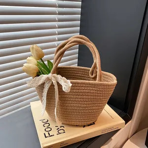 Handmade woven straw handbag with a white lace bow and yellow tulips for summer beach vacation