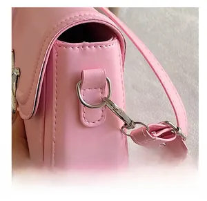 Dettaglio laterale della borsa rosa con anelli in metallo argento e ganci rimovibili