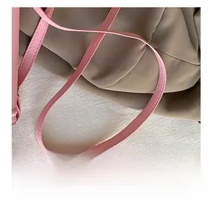 Dettaglio della tracolla in pelle PU rosa con cuciture fini per una piccola borsa quadrata