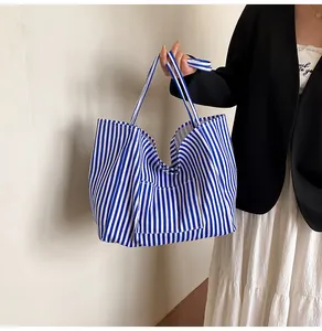 Close-up of blue and white striped canvas tote bag with front pocket and sturdy handles