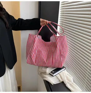 Macro detail of the red and white striped tote bag showing durable canvas and outer pocket
