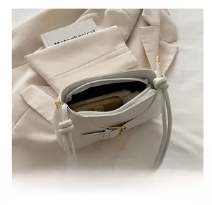 Vue détaillée du sac cabas crème avec boucle dorée montrant la capacité et la fermeture