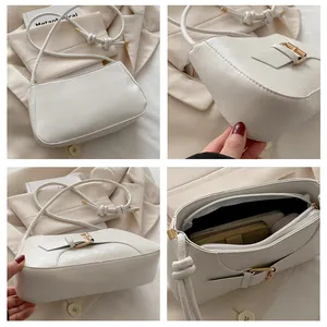 Détails du sac fourre-tout crème avec fermoir doré, bandoulière nouée et intérieur
