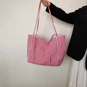 Classic red and white vertical stripe canvas tote bag with shoulder strap and front pocket