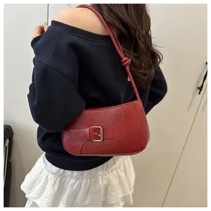 Détail du sac cabas en similicuir rouge avec bandoulière nouée et boucle métallique