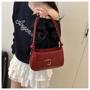 Détail du sac cabas rouge en similicuir avec boucle métallique et bandoulière à nœuds