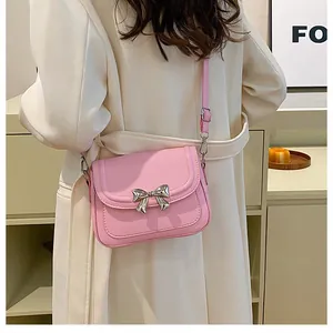 Vista posteriore di una borsa a tracolla rosa con fiocco su un cappotto bianco