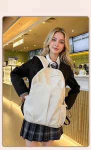 Sac à dos d'ordinateur blanc crème minimaliste montré dans un café avec poches latérales