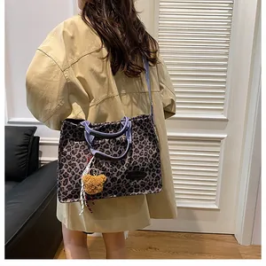 Leopard print canvas tote bag featuring a cute plush bear charm and blue straps