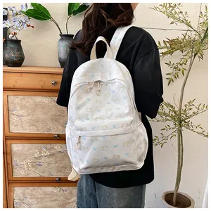Foto lifestyle che mostra il motivo a gatto e la tasca con zip dello zaino beige chiaro