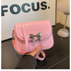 Vista dettagliata della borsa a tracolla rosa con fiocco argento e cuciture fini